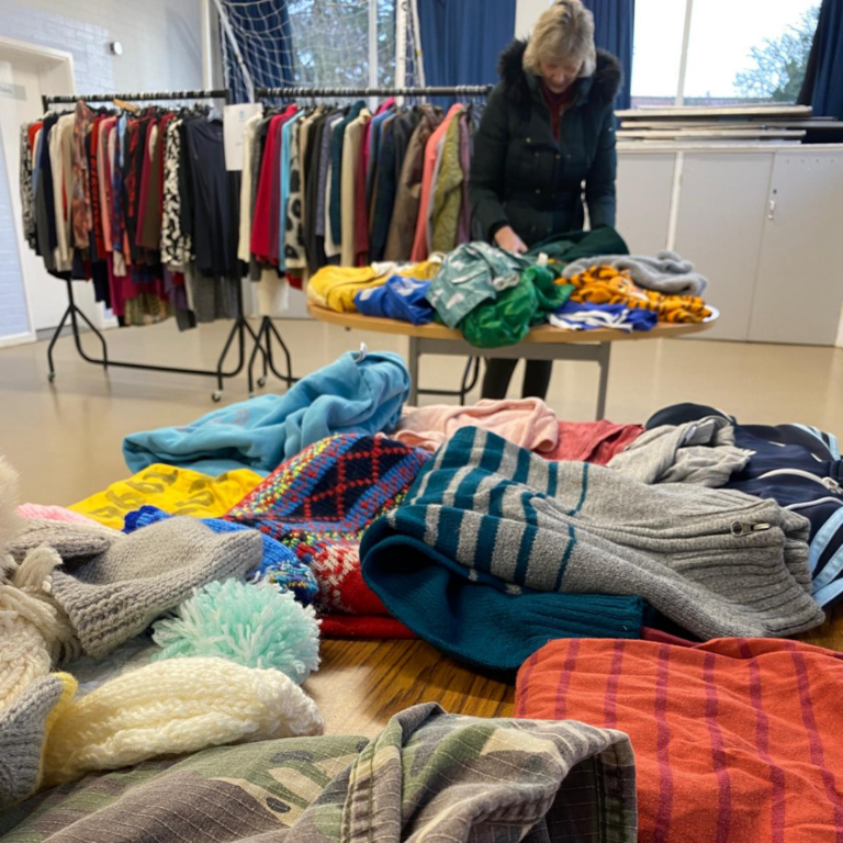 Volunteer setting up Nourishing Norfolk clothing at Watton pop up sale.