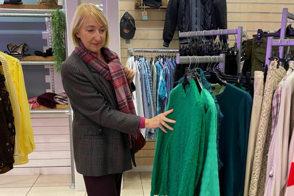 Customer browsing in the Norwich Shop looking at green top